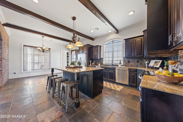 kitchen featuring a breakfast bar, beam ceiling, stone tile floors, and appliances with stainless steel finishes