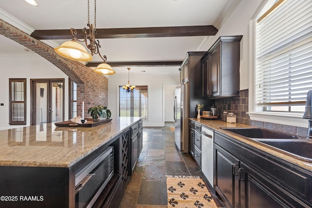 kitchen with a kitchen island, a sink, stainless steel appliances, stone tile flooring, and backsplash