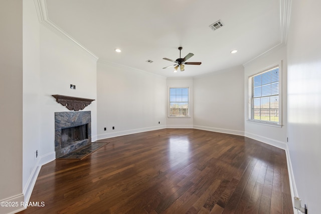 unfurnished living room with wood finished floors, visible vents, a wealth of natural light, and a premium fireplace