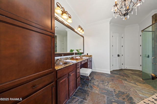 full bathroom featuring baseboards, a sink, stone tile flooring, a shower stall, and crown molding