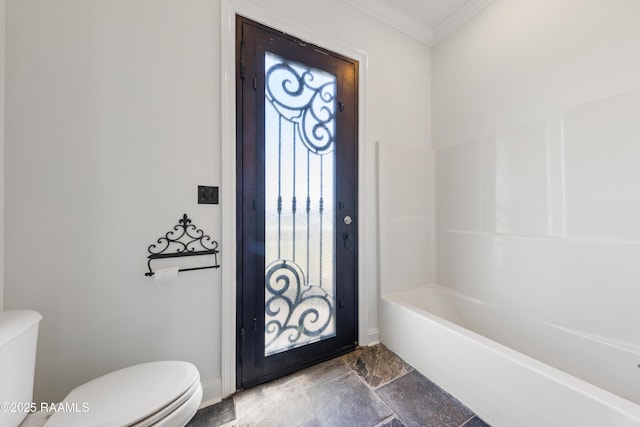 bathroom featuring crown molding, toilet, baseboards, and stone finish flooring