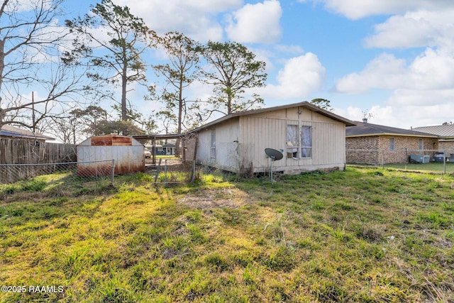 back of house featuring fence and a lawn