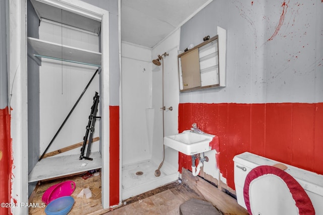 full bathroom with toilet, a stall shower, and a sink