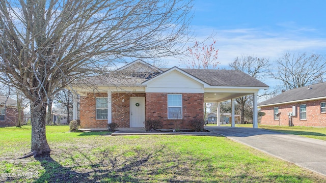 view of front facade with brick siding, a shingled roof, driveway, a carport, and a front yard