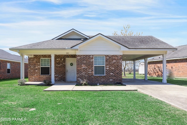 view of front of house featuring roof with shingles, a front lawn, concrete driveway, and brick siding