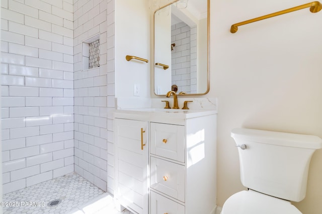 full bathroom featuring toilet, vanity, and a tile shower