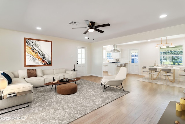 living area featuring light wood finished floors, visible vents, crown molding, ceiling fan, and recessed lighting