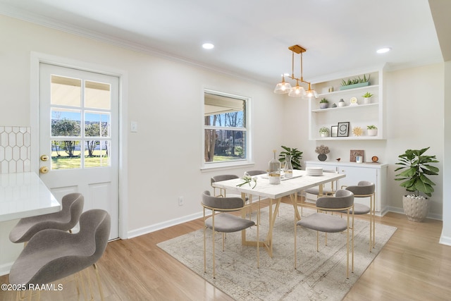 dining area with a wealth of natural light, baseboards, light wood-style floors, and ornamental molding