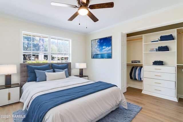 bedroom featuring a closet, light wood-style floors, crown molding, and a ceiling fan