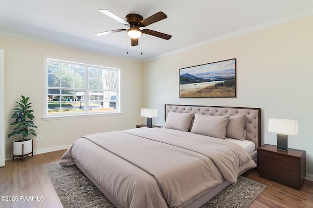 bedroom with ornamental molding, baseboards, and wood finished floors