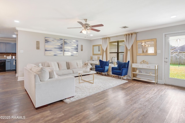 living area featuring baseboards, visible vents, a ceiling fan, ornamental molding, and wood finished floors