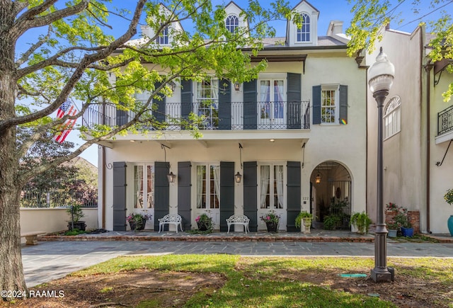 view of front of home with a balcony and stucco siding