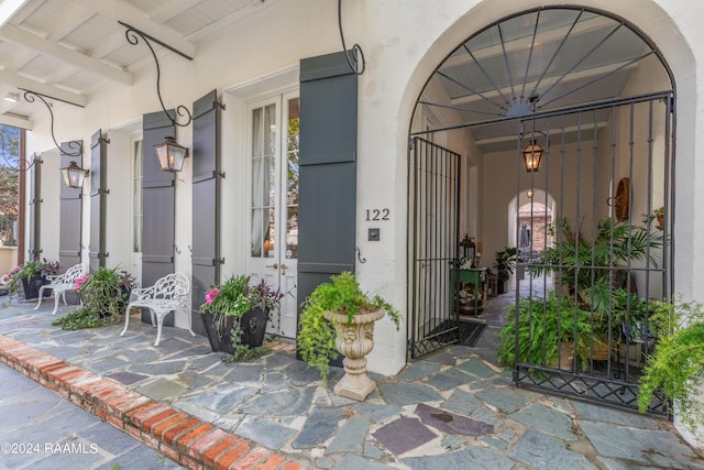 doorway to property with a gate and stucco siding