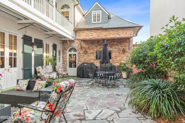 view of patio / terrace featuring outdoor dining space, an outdoor living space, a grill, and a balcony