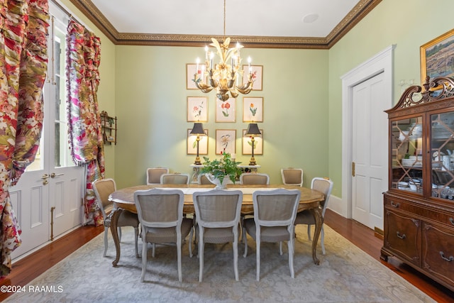 dining room with a notable chandelier, ornamental molding, and wood finished floors