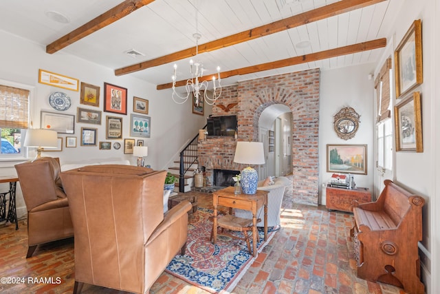 living room with visible vents, arched walkways, brick floor, a brick fireplace, and beam ceiling