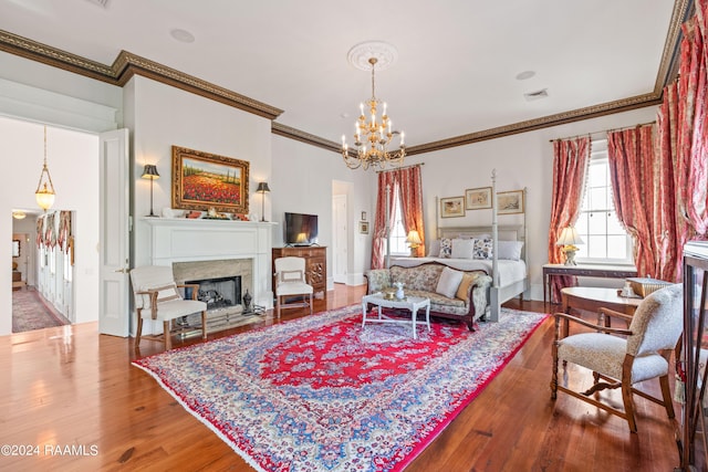 living area with a fireplace, wood finished floors, visible vents, baseboards, and an inviting chandelier