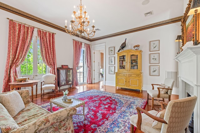 living area with ornamental molding, a fireplace, wood finished floors, and visible vents