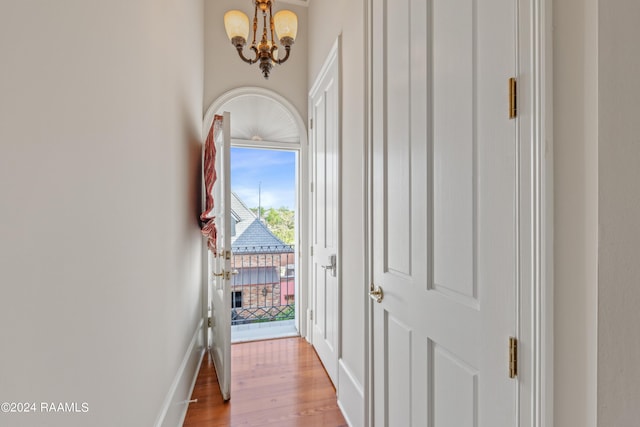 entryway featuring a chandelier, wood finished floors, and baseboards