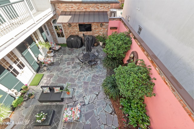 view of patio with a balcony, a grill, and visible vents