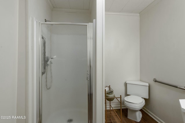 full bath featuring baseboards, toilet, wood finished floors, crown molding, and a shower stall