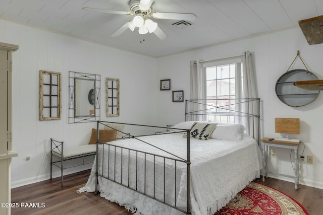 bedroom with visible vents, ceiling fan, baseboards, and wood finished floors