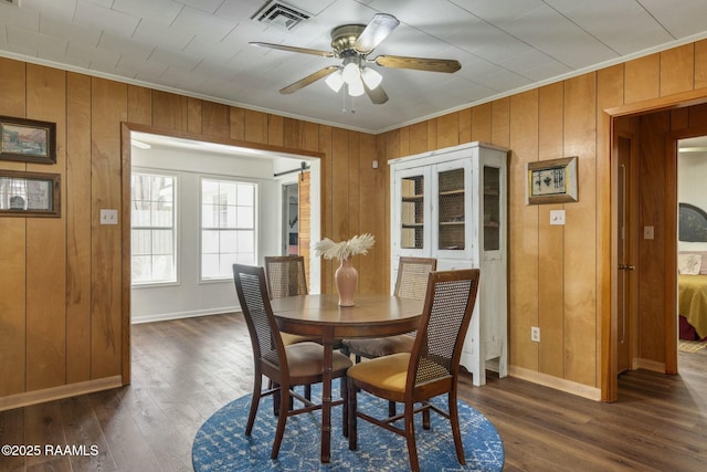 dining space featuring dark wood-style floors, ceiling fan, ornamental molding, and visible vents