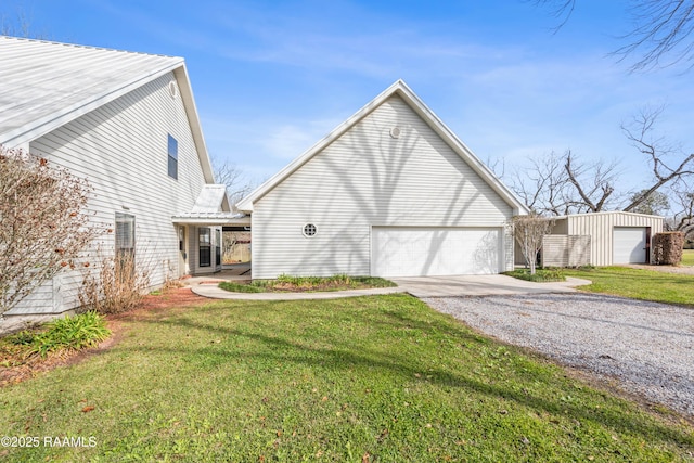view of side of home featuring a lawn, a garage, and driveway