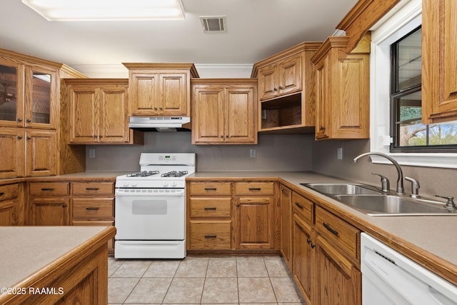 kitchen featuring white appliances, light tile patterned floors, visible vents, a sink, and under cabinet range hood