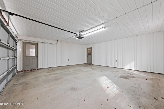 garage with a garage door opener and metal wall
