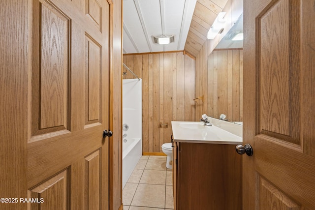 full bathroom with vanity, wooden walls,  shower combination, tile patterned floors, and toilet