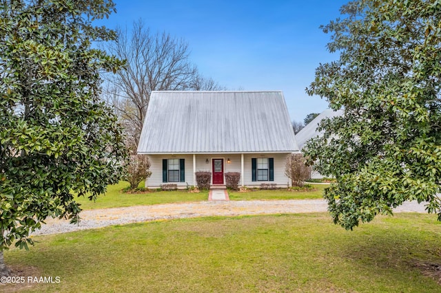 new england style home with metal roof, driveway, a front lawn, and a porch