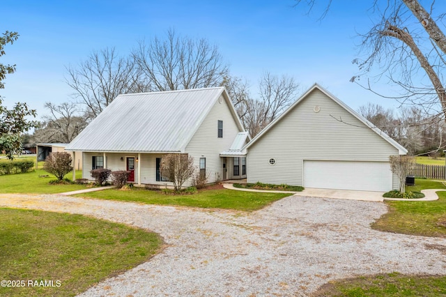 view of front facade featuring gravel driveway, a porch, a front yard, metal roof, and a garage