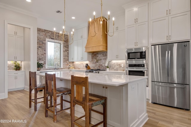 kitchen with stainless steel appliances, a kitchen island, visible vents, ornamental molding, and backsplash