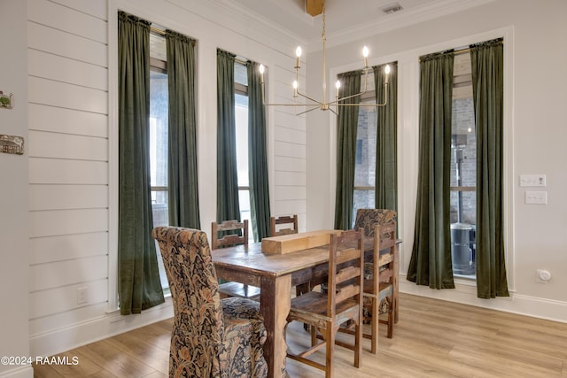 dining space featuring visible vents, ornamental molding, plenty of natural light, and light wood-style flooring