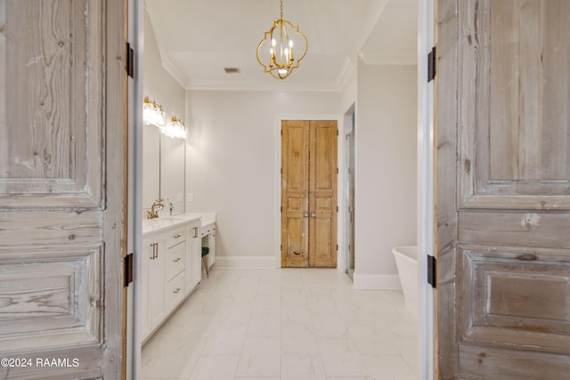 full bath with a notable chandelier, crown molding, vanity, a freestanding tub, and baseboards