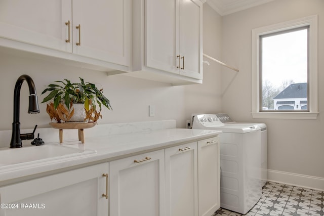 washroom featuring cabinet space, a sink, separate washer and dryer, baseboards, and tile patterned floors