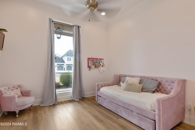 bedroom with crown molding, multiple windows, baseboards, and wood finished floors