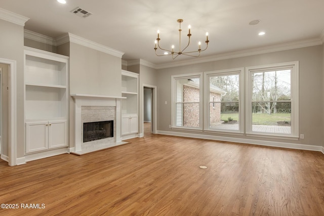 unfurnished living room featuring crown molding, a notable chandelier, light wood finished floors, visible vents, and a tiled fireplace