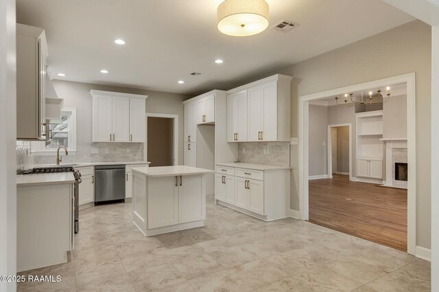 kitchen featuring light countertops, stainless steel dishwasher, visible vents, and white cabinets