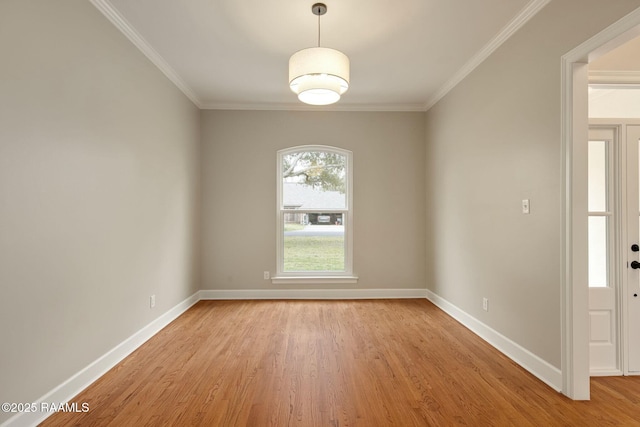 unfurnished room with crown molding, light wood-style flooring, and baseboards