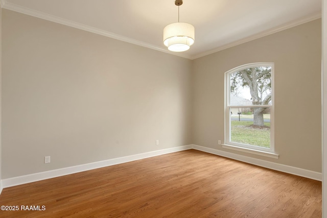 unfurnished room with baseboards, light wood-type flooring, and crown molding