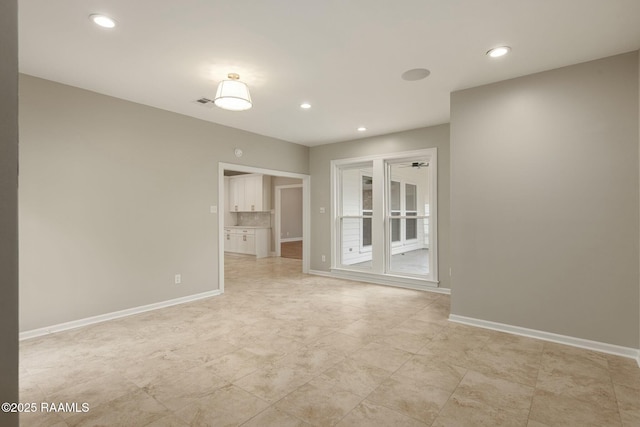 empty room featuring recessed lighting and baseboards