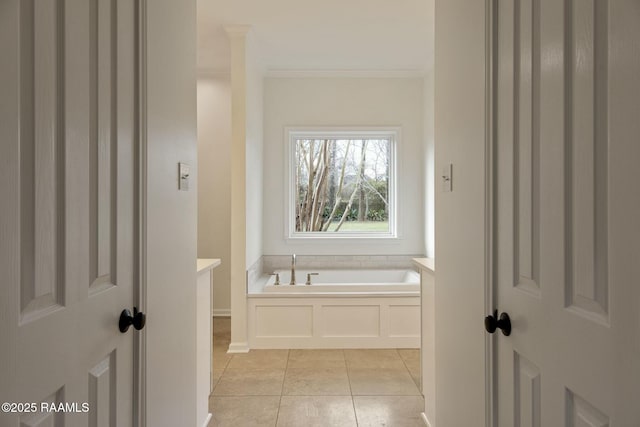 bathroom featuring a garden tub, crown molding, baseboards, and tile patterned floors