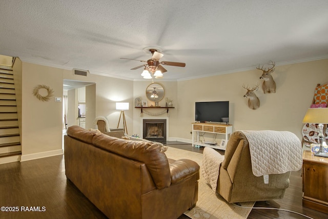 110 W Bayou Pkwy Unit 401, Lafayette, LA 70503 - living room with ceiling fan, dark wood-style floors, crown molding, a fireplace, and baseboards