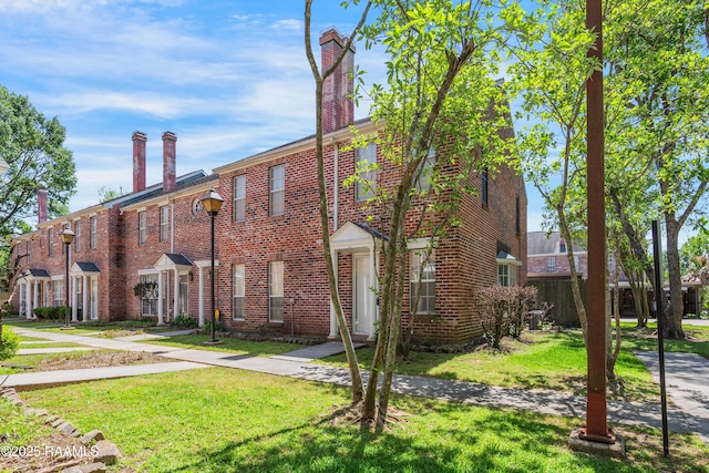 416 Doucet Rd Unit 5A, Lafayette, LA 70503 - view of front of property featuring a front yard, brick siding, and a chimney
