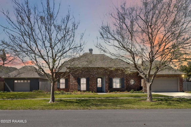 single story home with driveway, fence, a lawn, and brick siding