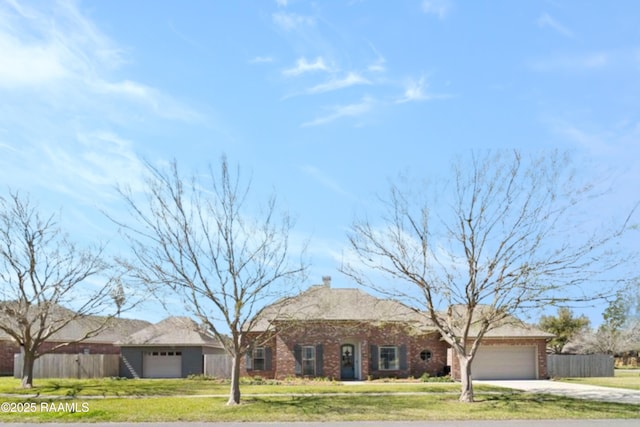 view of front of home with fence, concrete driveway, a front yard, and an attached garage