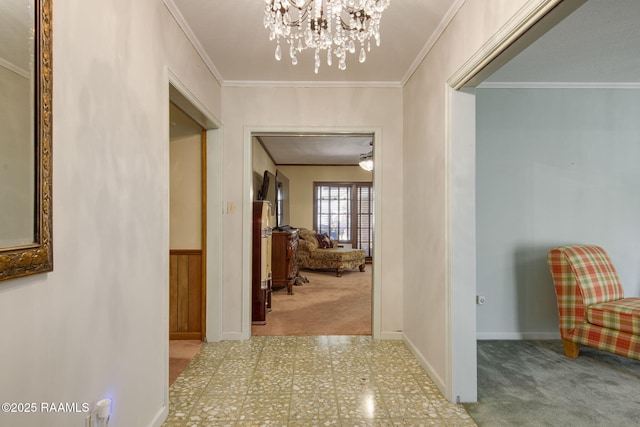 hallway featuring tile patterned floors, carpet floors, an inviting chandelier, crown molding, and baseboards