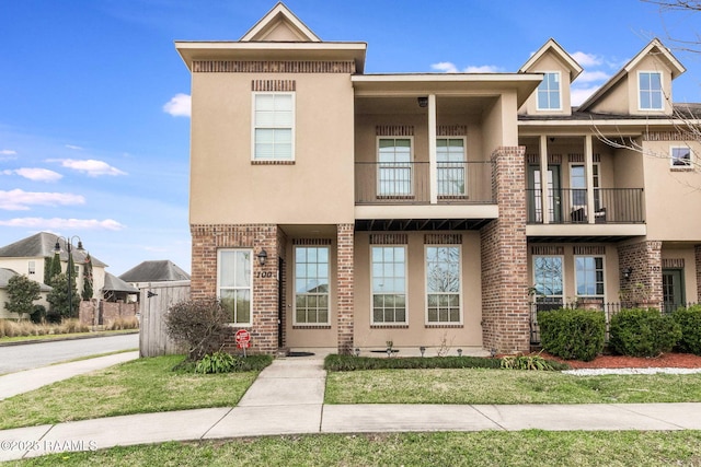 townhome / multi-family property featuring brick siding and stucco siding